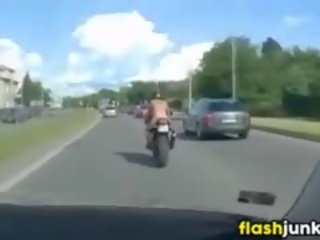 Toppløs tatovert kvinne ridning en motorcycle